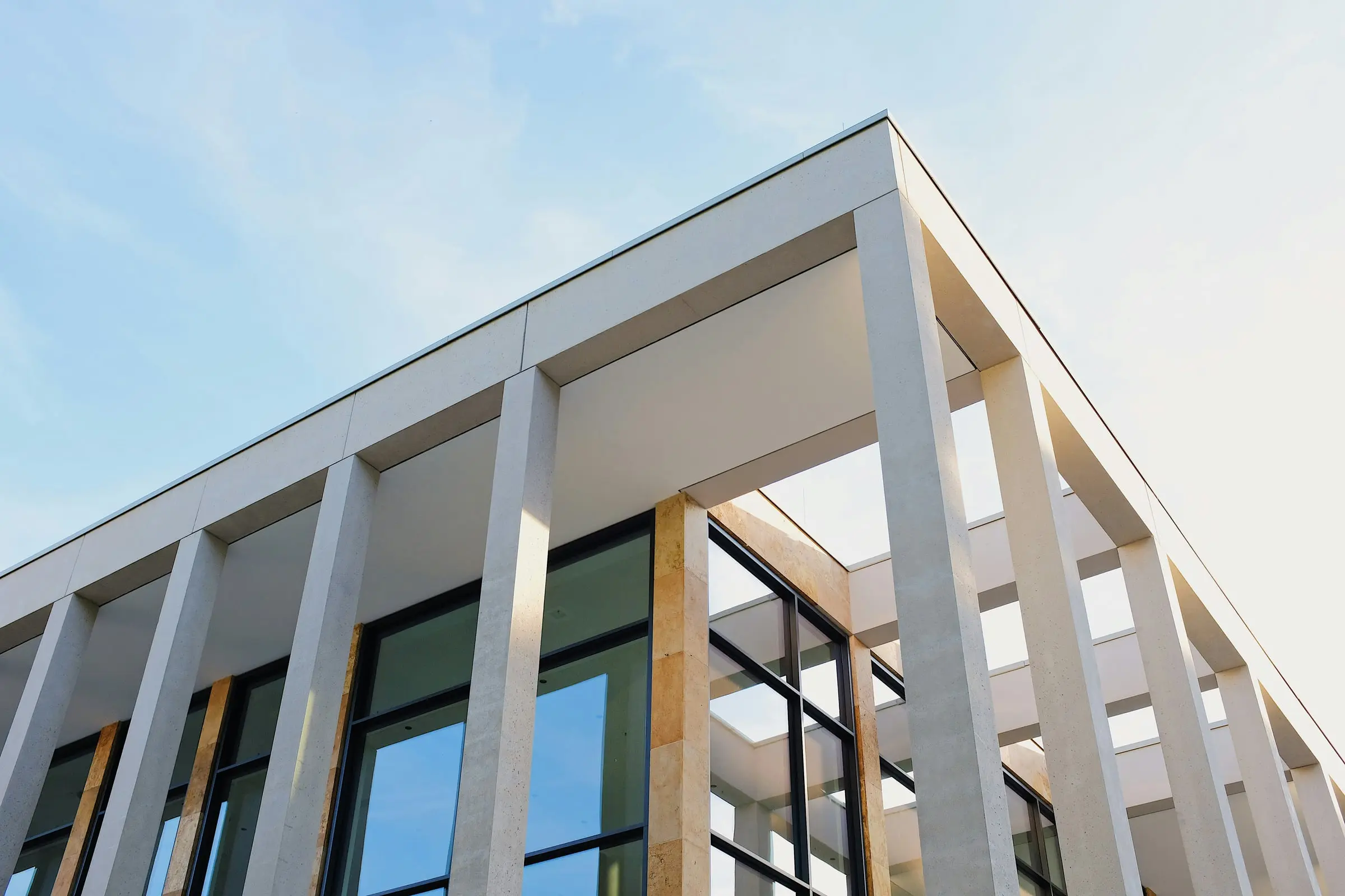 Corner of a white building with tall columns against a pale sky