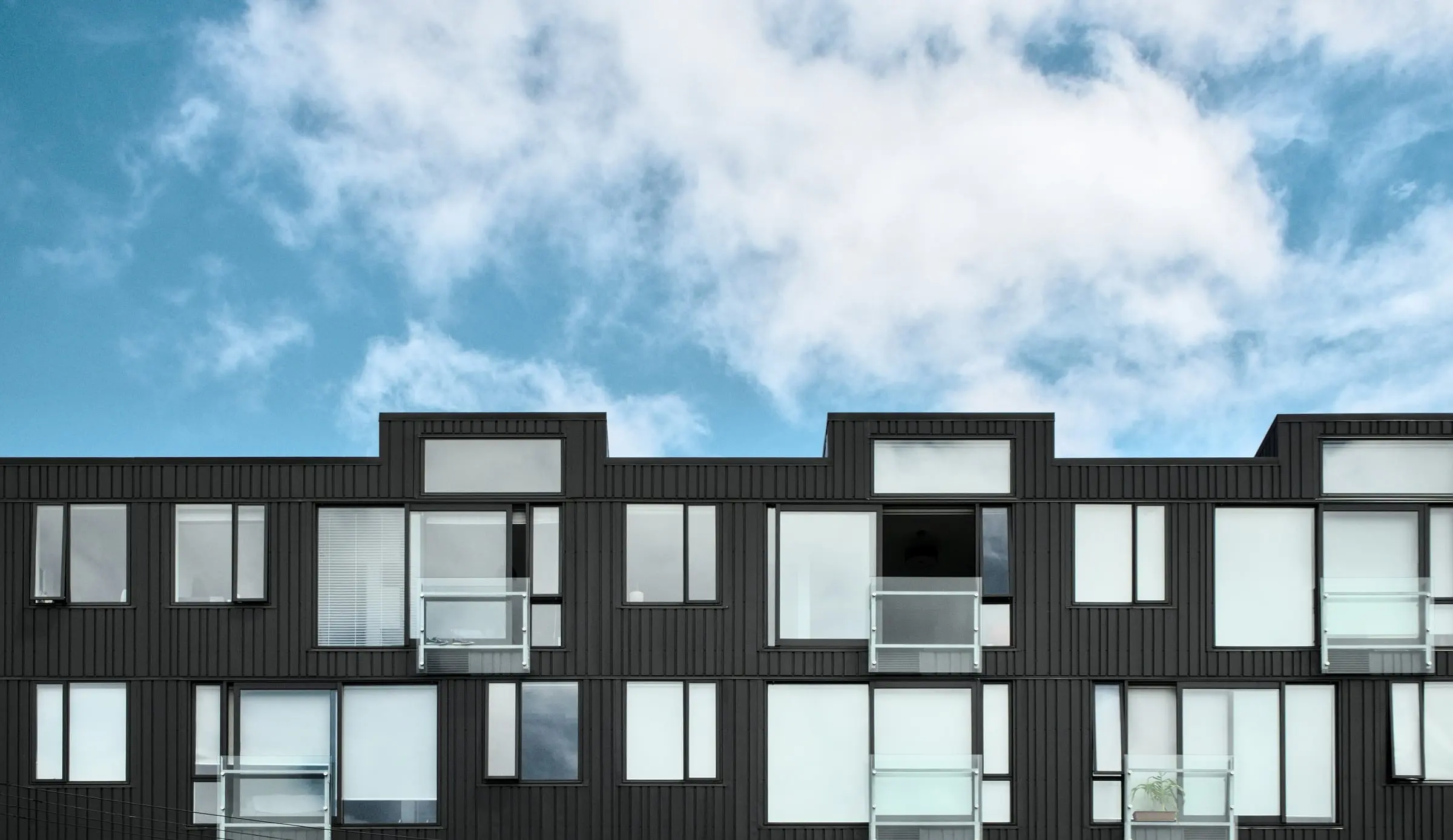 Contemporary multifamily residential building under a cloudy sky