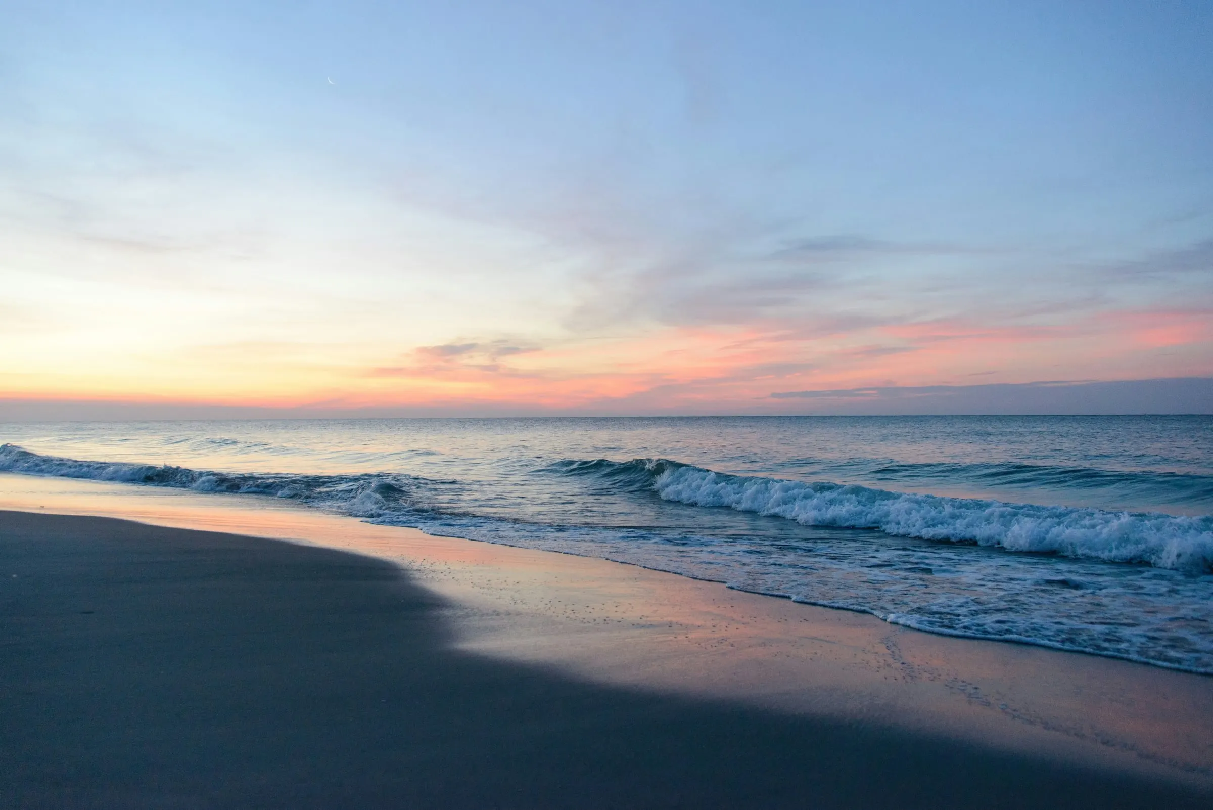 Soft waves along a quiet shoreline at dawn